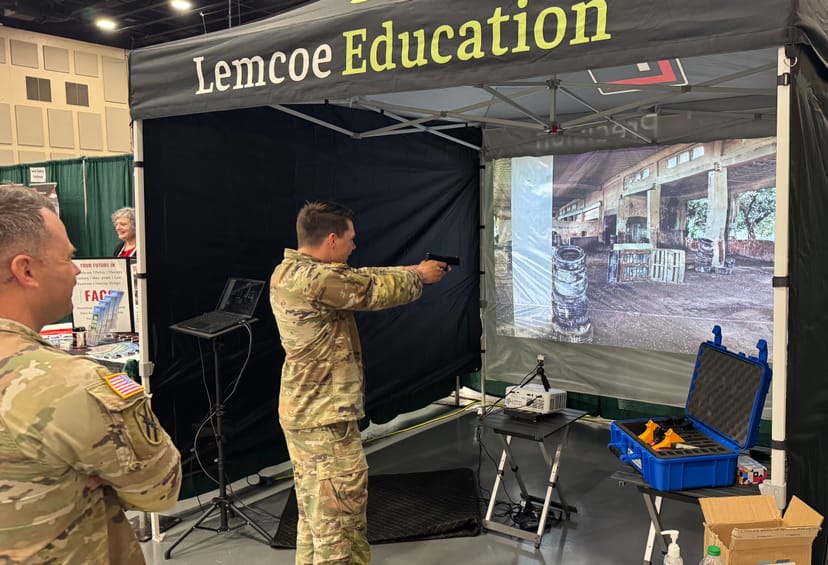 Soldier engages a use-of-force simulator scenario at the Lemcoe Education expo booth