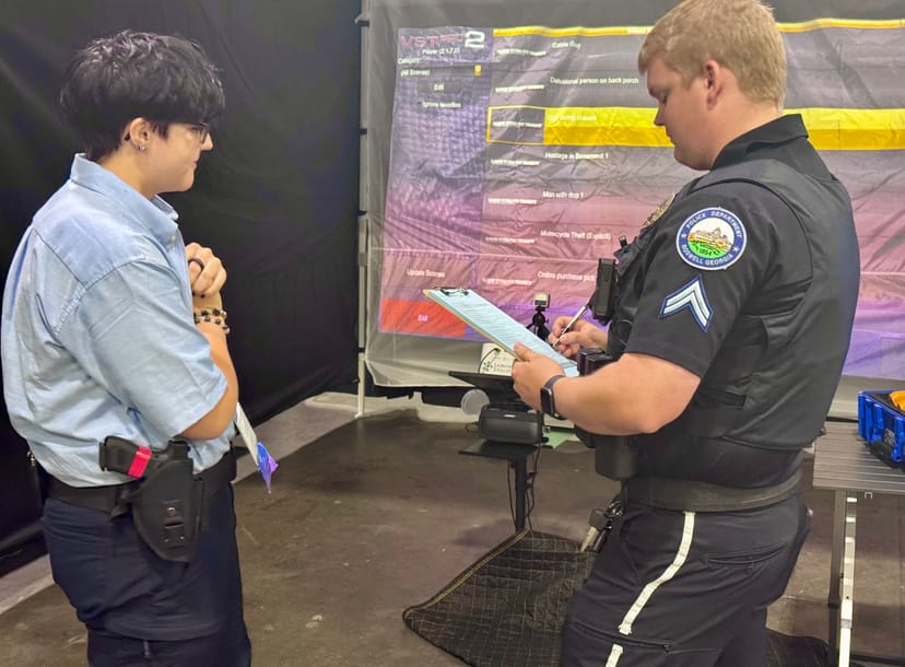 Police officer and student reviewing training scenarios at a Lemcoe Education demonstration